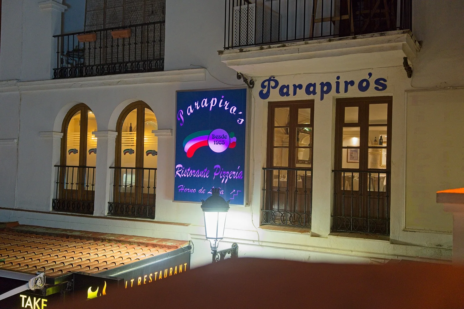 Entrada de Parapirós con su rótulo iluminado en el Puerto de la Duquesa, Manilva